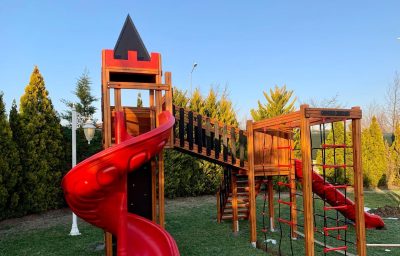 Kırmızı kaydıraklı ahşap oyun kalesi — Elysee